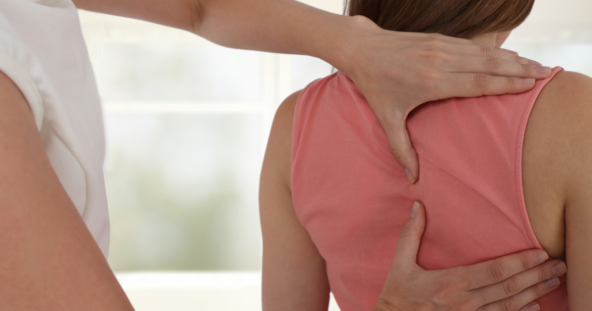 osteopath doing manual therapy on a female patient on her back spine
