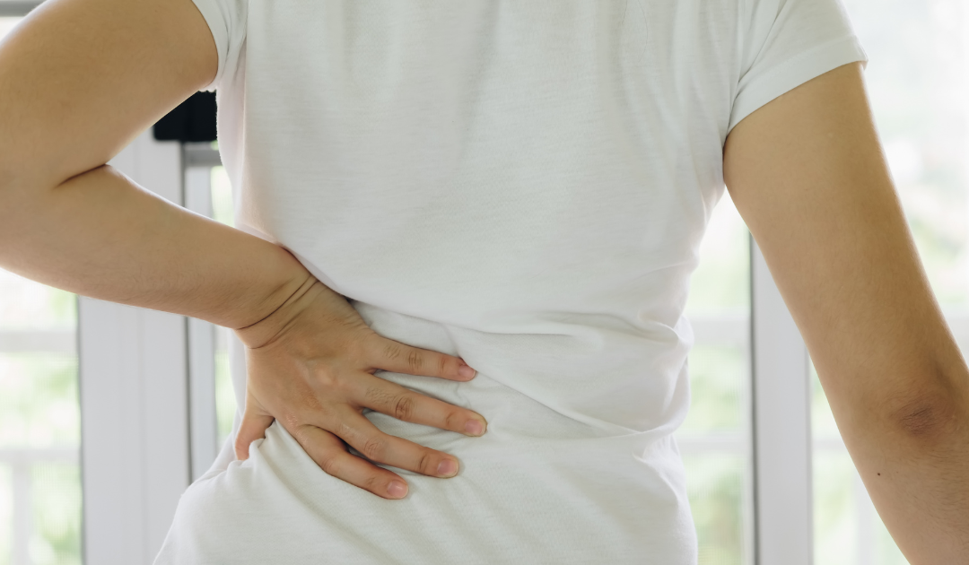Photo of someone holding their lower back in pain