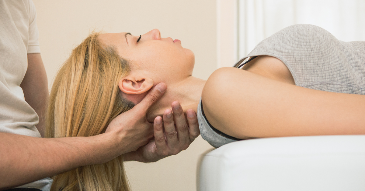 Practitioner supporting a woman's neck and spine