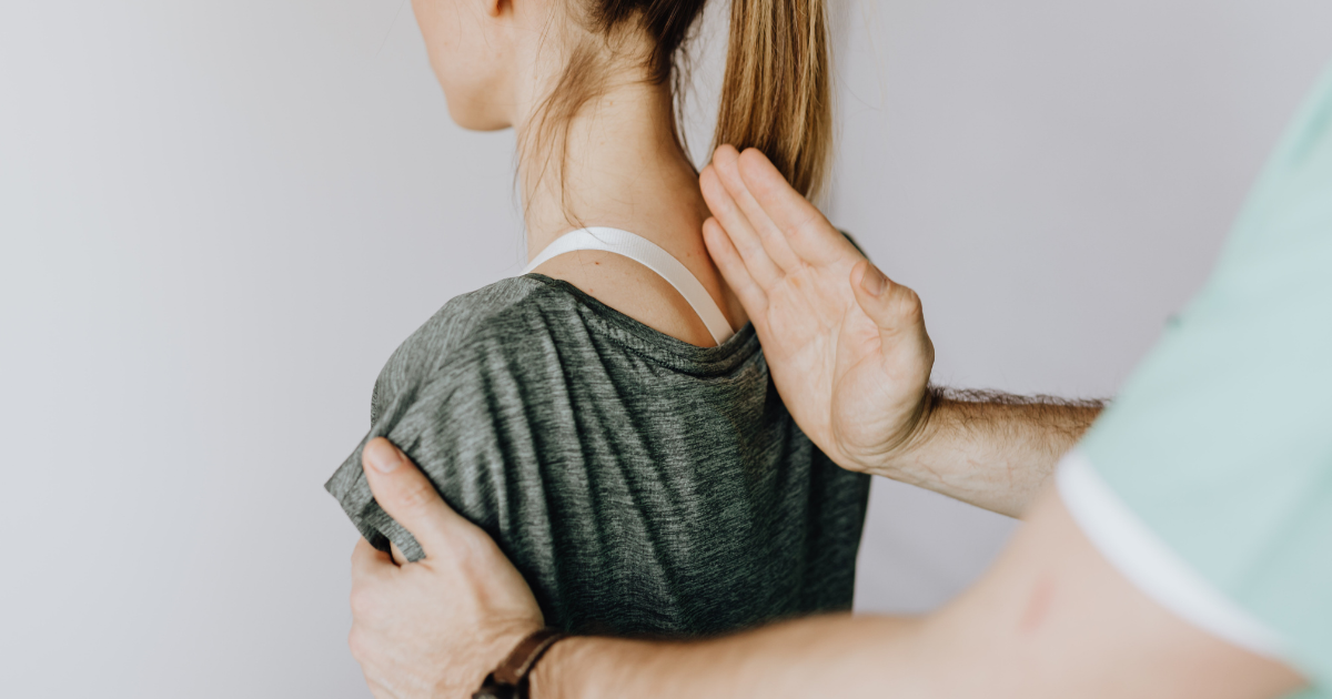 Photo of a woman's back doing manual therapy by a chiropractor